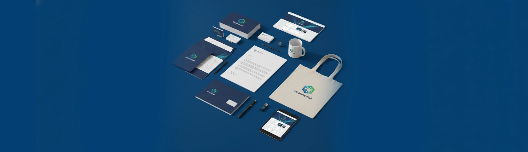 Overhead view of a collection of branded items including a tote bag, mug, stationery, folder, and tablet, all featuring a consistent "Innovate Hub" logo and branding.