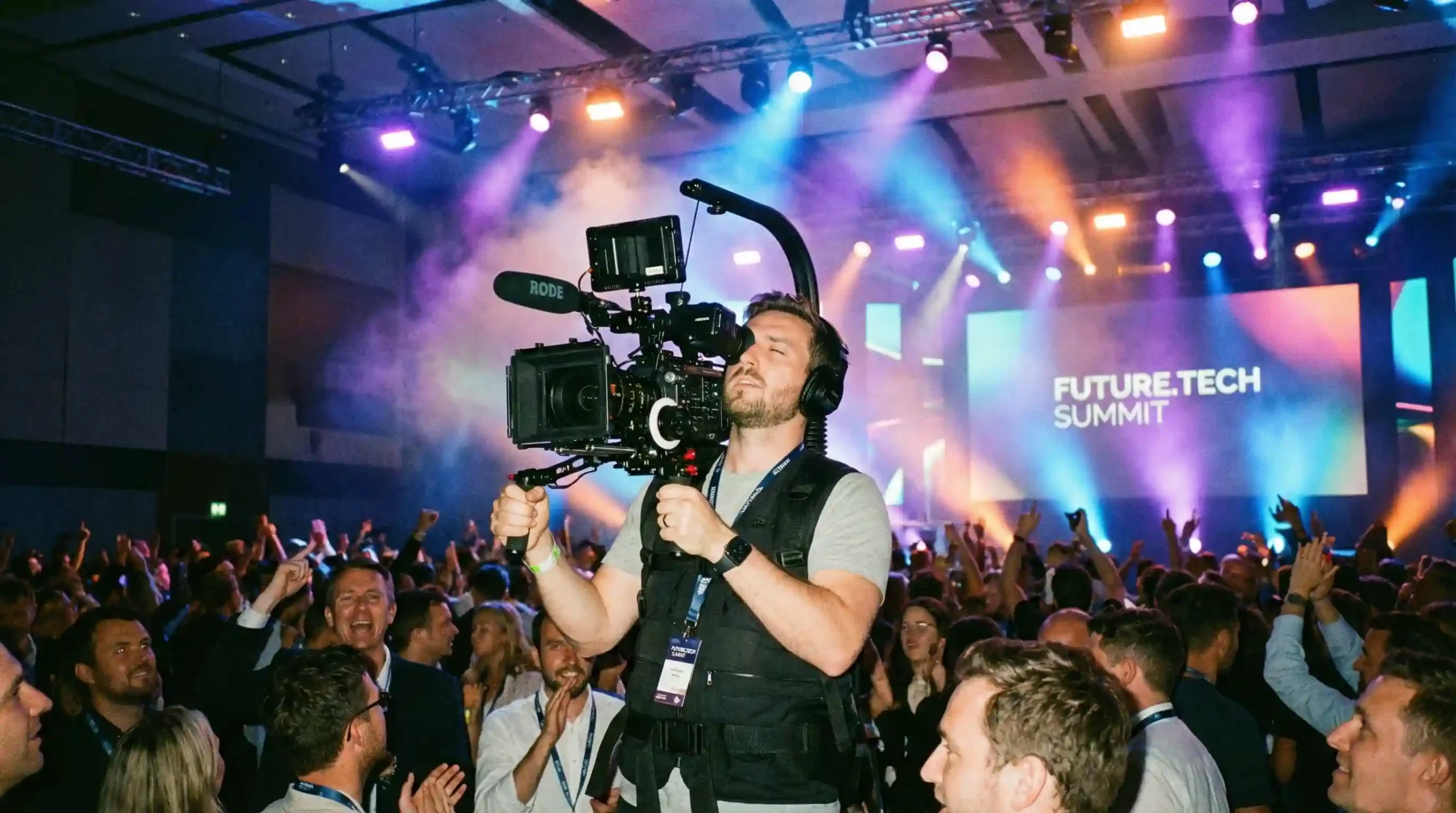 Professional videographer using gimbal stabilizer to film a high-energy corporate tech summit.