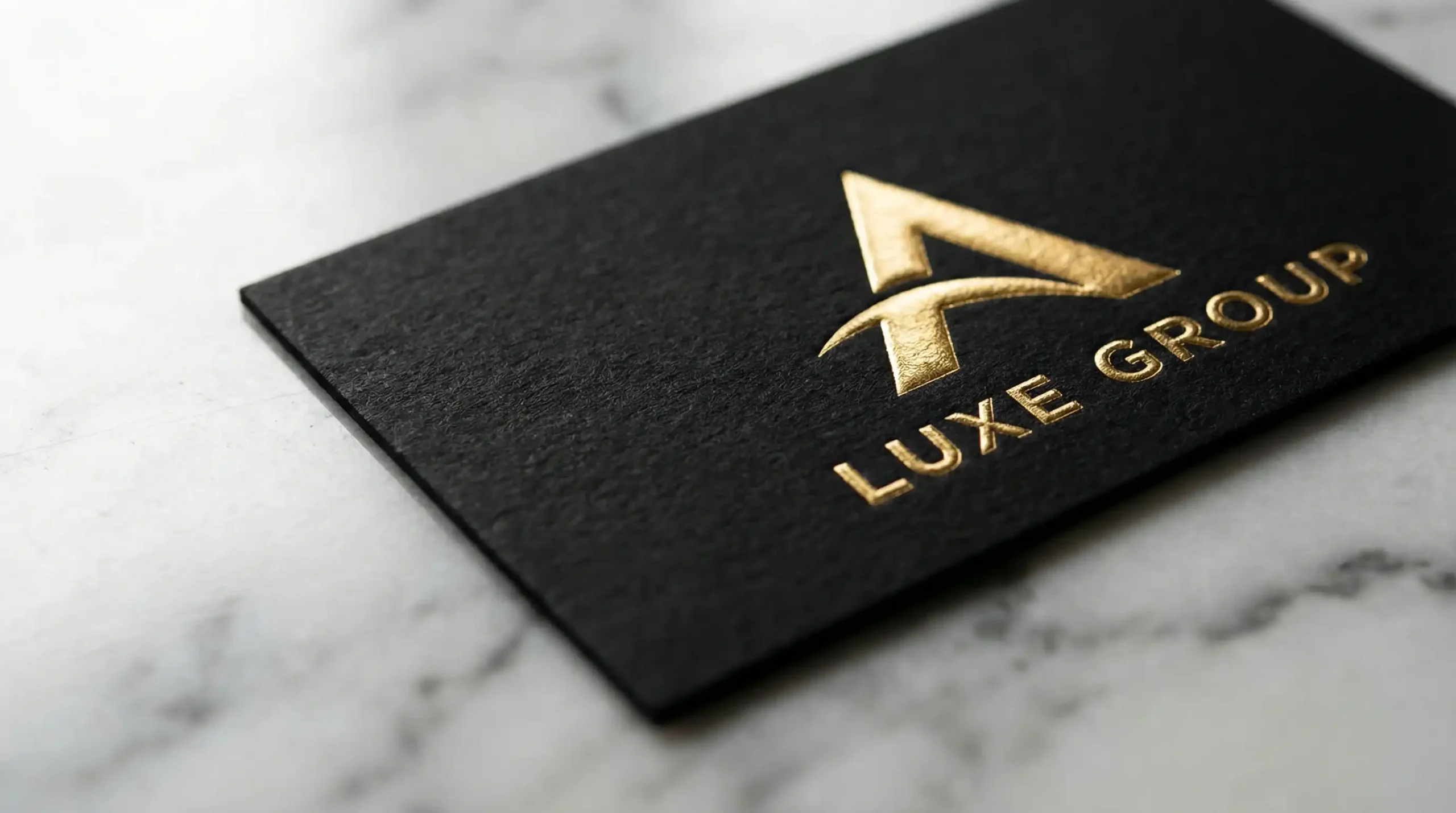 Luxury real estate branding material with gold foil embossing on textured paper.